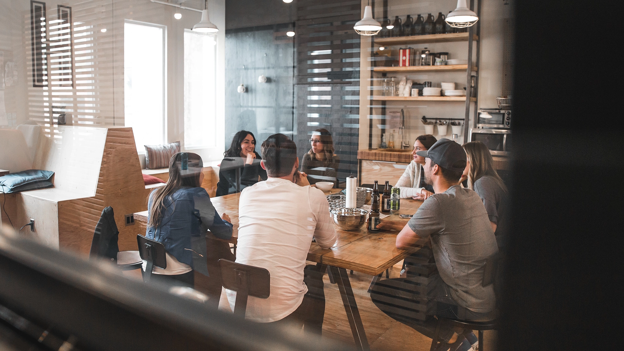 A group of people having a meeting in an room with glass walls